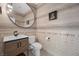 Stylish half bathroom with a modern vanity, round mirror, and decorative tiled walls at 11826 Corenzio Ave, Las Vegas, NV 89138