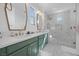 Modern bathroom with dual sinks, decorative mirrors, green cabinets, and a marble-tiled walk-in shower at 11826 Corenzio Ave, Las Vegas, NV 89138