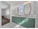 Modern bathroom featuring double sinks, decorative mirrors, green cabinets, and white marble flooring at 11826 Corenzio Ave, Las Vegas, NV 89138
