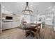 Open-concept dining area with modern lighting, seamlessly connected to the living room and kitchen at 11826 Corenzio Ave, Las Vegas, NV 89138