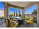 Covered patio seating area features a gas fire pit and serene pool views at 11826 Corenzio Ave, Las Vegas, NV 89138