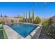 Sparkling backyard pool with travertine surround, privacy wall and lush landscaping at 11826 Corenzio Ave, Las Vegas, NV 89138