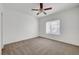 Carpeted bedroom is brightened by a large window and features a ceiling fan and simple decor at 1840 N Jones Blvd, Las Vegas, NV 89108