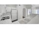 Compact kitchen featuring white appliances, tiled countertops, and ample storage space with a view into the hallway at 1840 N Jones Blvd, Las Vegas, NV 89108