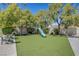 Spacious backyard with lush lawn, mature trees, and a play area at 1853 Heydon Ct, Henderson, NV 89014