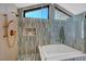 Bright bathtub and shower with unique tiling, gold hardware, and toiletries at 1853 Heydon Ct, Henderson, NV 89014