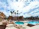View of the community pool area with multiple pools, palm trees, lounge chairs, and multi-story condos at 1964 Las Palmas Ln # 244, Laughlin, NV 89029