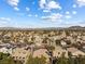 Wide aerial view of a residential neighborhood with homes, palm trees, and mountain views at 2163 Fountain Springs Dr, Henderson, NV 89074