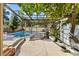 Charming backyard with a covered patio, lush greenery, and a refreshing pool for outdoor entertainment and relaxation at 2163 Fountain Springs Dr, Henderson, NV 89074