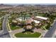 Wide aerial shot of an expansive community center with swimming pools, lush landscaping, and ample parking at 228 Via Vallisneri, Henderson, NV 89011