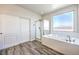 Bathroom with a soaking tub, walk-in shower, and wood-look tile flooring at 228 Via Vallisneri, Henderson, NV 89011
