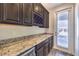 Butler pantry with granite countertops, wine rack, cabinets, and convenient access to the outside at 228 Via Vallisneri, Henderson, NV 89011