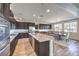 Open kitchen with granite countertops, dark cabinets, stainless appliances, and a spacious dining area at 228 Via Vallisneri, Henderson, NV 89011
