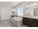 Elegant bathroom featuring dual vanities, granite countertops, a soaking tub and a frosted window at 274 Chartan Ave, Las Vegas, NV 89183
