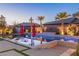 Backyard pool with tanning deck, lounge chairs, umbrellas, and well manicured yard in a modern home at dusk at 274 Chartan Ave, Las Vegas, NV 89183