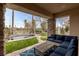 Inviting covered patio with stone columns and blue outdoor seating overlooking the backyard spa at 2822 Soft Horizon Way, Las Vegas, NV 89135