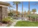 Backyard spa with rock accents, surrounded by lush landscaping and mature palm trees at 2822 Soft Horizon Way, Las Vegas, NV 89135