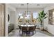 Bright dining room featuring a round table, modern chandelier, and views of the landscaped outdoors at 2822 Soft Horizon Way, Las Vegas, NV 89135