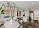 Open dining space with modern lighting, island seating, and stainless appliances visible in the kitchen at 2822 Soft Horizon Way, Las Vegas, NV 89135
