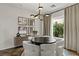 Inviting dining room with round table, modern fixture, designer decor, and outdoor view with lush foliage at 2822 Soft Horizon Way, Las Vegas, NV 89135