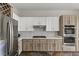 Well-appointed kitchen with stainless steel appliances, stone floors, and modern cabinets at 2822 Soft Horizon Way, Las Vegas, NV 89135