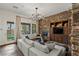 Spacious living room with a stone accent wall, modern furniture, and access to the backyard at 2822 Soft Horizon Way, Las Vegas, NV 89135