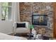 Cozy living room with a stone fireplace and comfortable armchair near a window at 2822 Soft Horizon Way, Las Vegas, NV 89135