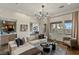 Bright living room featuring a large sectional sofa, modern chandelier, and an open view of the outdoor landscape at 2822 Soft Horizon Way, Las Vegas, NV 89135