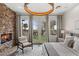 Beautiful main bedroom featuring a stacked stone fireplace and backyard access with palm tree views at 2822 Soft Horizon Way, Las Vegas, NV 89135