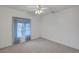Carpeted bedroom with neutral walls and a large window with sheer blue curtains at 3020 Ripon Dr, Las Vegas, NV 89134