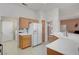 Kitchen area with white appliances, light wood cabinets and tile countertops and floors at 3020 Ripon Dr, Las Vegas, NV 89134