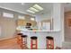 Bright kitchen with wood cabinets, breakfast bar and three stools below a skylight at 3020 Ripon Dr, Las Vegas, NV 89134