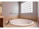 Bright bathroom features a tiled surround tub with tile accents and a large window at 3920 Eiderdown Pl, North Las Vegas, NV 89084