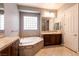 Bright Primary bathroom with double vanities, a soaking tub, and ample storage at 3920 Eiderdown Pl, North Las Vegas, NV 89084