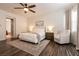 Comfortable bedroom featuring a ceiling fan, neutral decor, and a sitting area with an accent chair at 3920 Eiderdown Pl, North Las Vegas, NV 89084