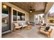 Relaxing covered patio features comfortable seating, ceiling fan, and view of the landscaped backyard at 3920 Eiderdown Pl, North Las Vegas, NV 89084