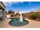 Inviting pool area with a relaxing spa, surrounded by palm trees and an umbrella for shade at 3920 Eiderdown Pl, North Las Vegas, NV 89084