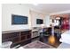 Bright living area featuring dark wood flooring, built-in shelving with a TV, desk, and partially open kitchen at 4381 W Flamingo Rd # 2605, Las Vegas, NV 89103