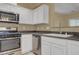 Well-lit kitchen with white cabinets, stainless steel appliances, and dark countertops at 4685 Apulia Dr # 202, North Las Vegas, NV 89084