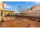 Wide backyard with covered patio, block fence, rock landscaping and fire pit area at 5019 Cactus Mesa Way, North Las Vegas, NV 89031