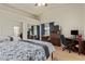Bright bedroom featuring a ceiling fan, closet with mirrored doors, and workspace with a desk at 5019 Cactus Mesa Way, North Las Vegas, NV 89031