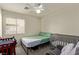 Cozy bedroom featuring a ceiling fan, full bed, and a crib, with soft natural light at 5019 Cactus Mesa Way, North Las Vegas, NV 89031