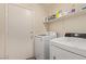Bright laundry room featuring modern washer and dryer, shelving, and a convenient utility sink at 5019 Cactus Mesa Way, North Las Vegas, NV 89031