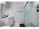 Updated bathroom featuring a white vanity with a black faucet and hardware, plus a shower with decorative tile at 5049 Hibbetts Ct, Las Vegas, NV 89103
