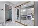 Bright bathroom with a glass-enclosed shower, granite countertop vanity, and gold framed mirrored closet with bedroom access at 5049 Hibbetts Ct, Las Vegas, NV 89103