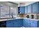 Kitchen featuring blue cabinets, granite countertops, sink, and stainless steel appliances at 5049 Hibbetts Ct, Las Vegas, NV 89103