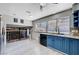 Bright kitchen features blue cabinets, stainless steel appliances, and a view of the living room through the railing at 5049 Hibbetts Ct, Las Vegas, NV 89103