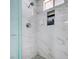 Shower featuring marble-look wall tile, a gray tile floor, a shower niche, and a sleek, modern shower head at 5049 Hibbetts Ct, Las Vegas, NV 89103