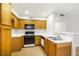 Inviting kitchen with wooden cabinets, black appliances, and ample counter space at 5130 Mandalay Springs Dr # 102, Las Vegas, NV 89120