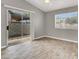 Bright bedroom with laminate floors, window, and sliding glass door leading to a small patio at 537 Inness Ave, Henderson, NV 89011